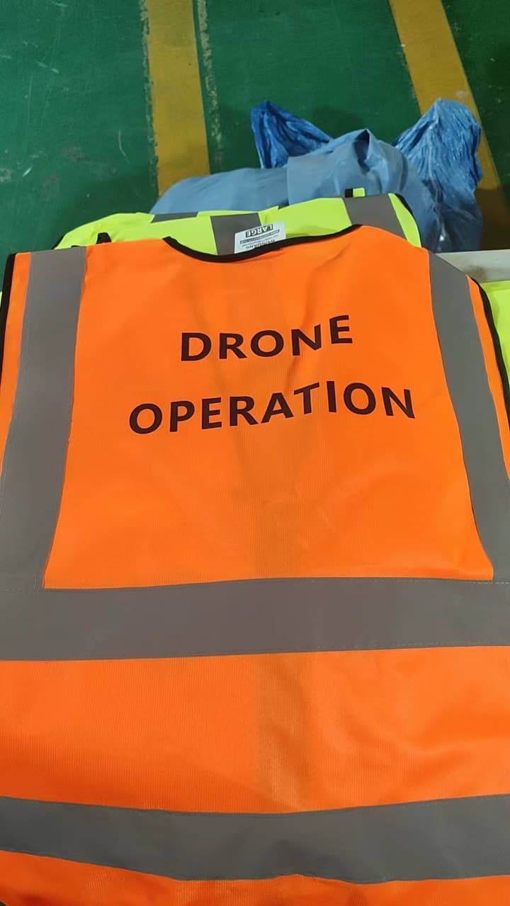 Back of orange safety vest printed with Drone Operation